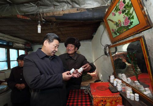2012年12月30日，習(xí)近平在龍泉關(guān)鎮(zhèn)駱駝灣村困難群眾唐榮斌家，詳細(xì)詢問身體有病的唐榮斌（右）日常服藥情況。