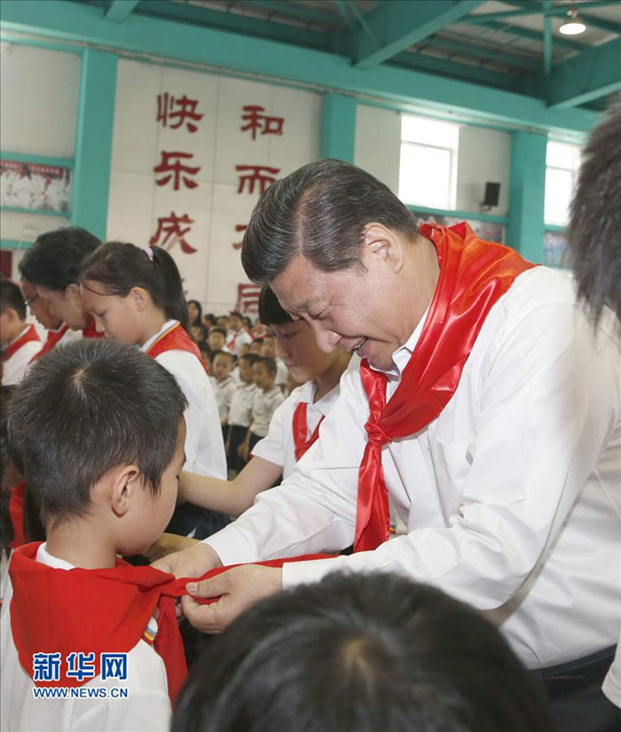2014年5月30日上午，習近平來到北京市海澱區(qū)民族小學，參加慶祝“六一”國際兒童節(jié)活動。這是習近平在少先隊入隊儀式上，為新少先隊員系上紅領巾。新華社記者 鞠鵬 攝