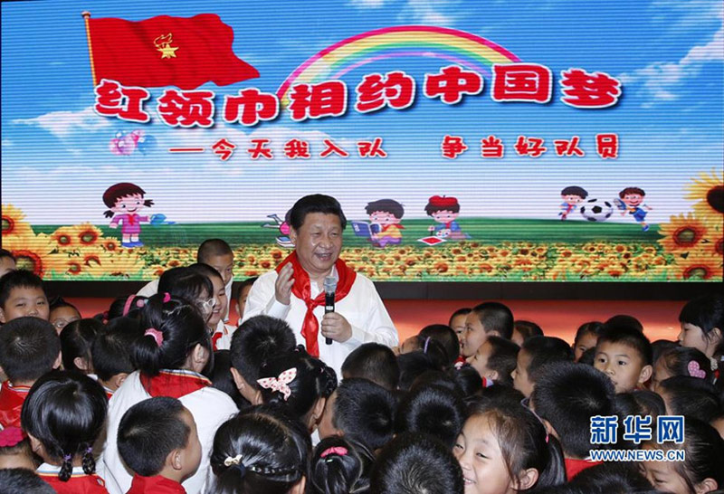 2014年5月30日上午，習(xí)近平來到北京市海澱區(qū)民族小學(xué)，參加慶?！傲弧眹H兒童節(jié)活動。這是習(xí)近平在參加少先隊入隊儀式時，向少先隊員們致以節(jié)日問候。新華社記者 鞠鵬 攝