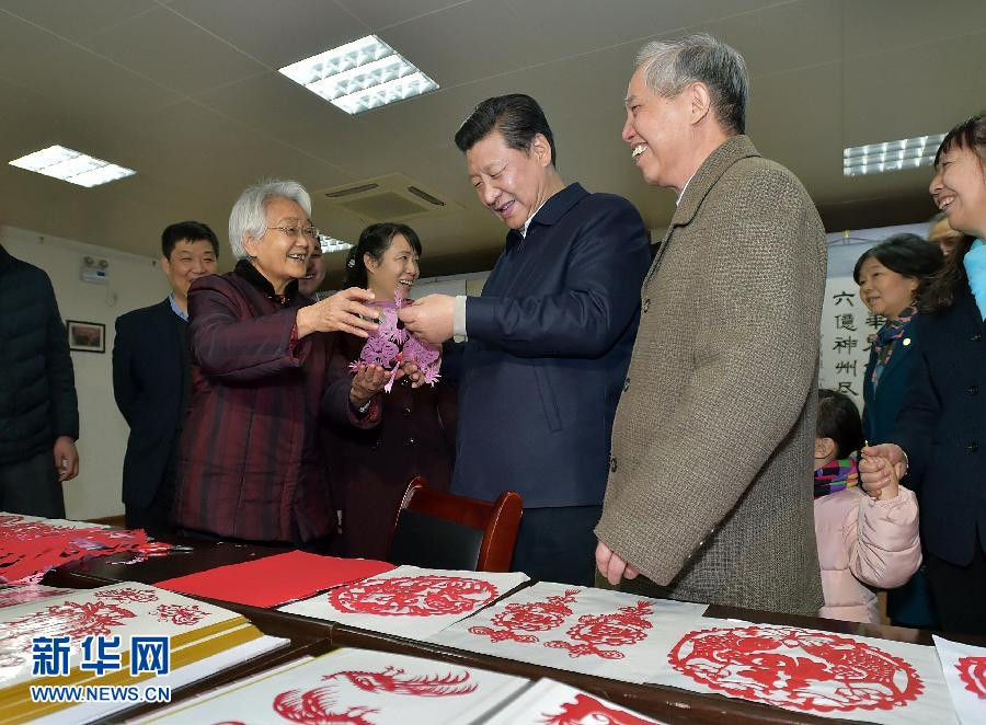 2月15日上午，習(xí)近平在西安市雁塔區(qū)電子城街道二〇五所社區(qū)服務(wù)中心欣賞社區(qū)老人的剪紙作品。新華社記者 李濤 攝