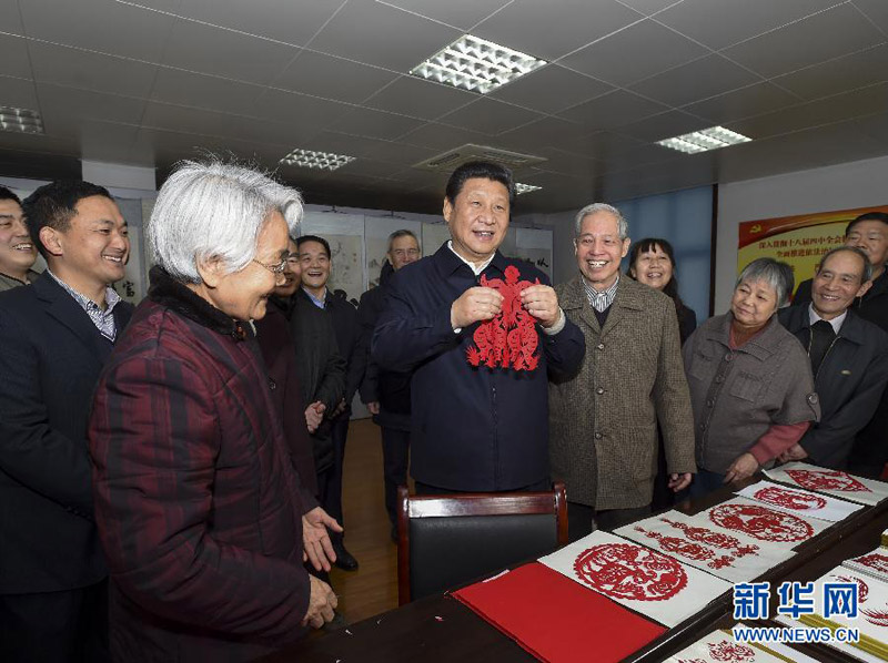 這是15日上午，習(xí)近平在西安市雁塔區(qū)電子城街道二〇五所社區(qū)服務(wù)中心，拿起一幅“三陽開泰”剪紙，祝願全國各族人民新春愉快、羊年大吉，生活喜氣洋洋，事業(yè)蒸蒸日上。新華社記者 李學(xué)仁 攝