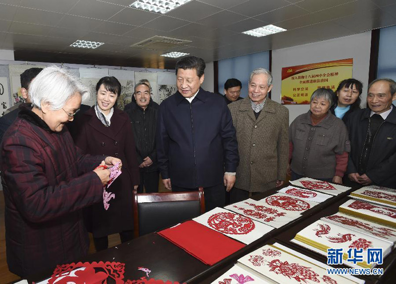這是15日上午，習(xí)近平在西安市雁塔區(qū)電子城街道二〇五所社區(qū)服務(wù)中心觀(guān)看社區(qū)居民的剪紙藝術(shù)。新華社記者 李學(xué)仁 攝