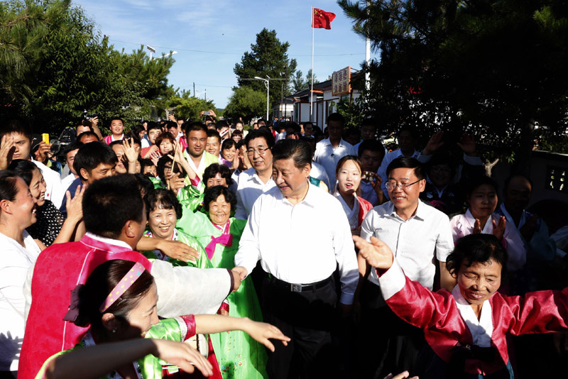 這是7月16日，習(xí)近平在延邊州和龍市東城鎮(zhèn)光東村同當(dāng)?shù)厝罕娫谝黄?。新華社記者 鞠鵬 攝
