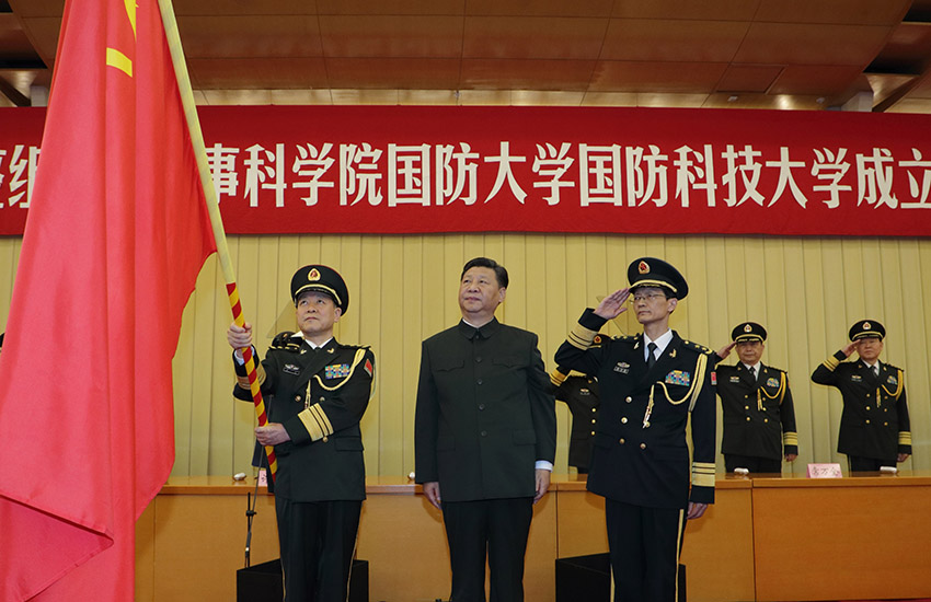 7月19日，新調(diào)整組建的軍事科學(xué)院、國(guó)防大學(xué)、國(guó)防科技大學(xué)成立大會(huì)暨軍隊(duì)院校、科研機(jī)構(gòu)、訓(xùn)練機(jī)構(gòu)主要領(lǐng)導(dǎo)座談會(huì)在北京八一大樓舉行。中共中央總書記、國(guó)家主席、中央軍委主席習(xí)近平向軍事科學(xué)院、國(guó)防大學(xué)、國(guó)防科技大學(xué)授軍旗、致訓(xùn)詞，出席座談會(huì)並發(fā)表重要講話。這是習(xí)近平將軍旗鄭重授予國(guó)防大學(xué)校長(zhǎng)鄭和、政治委員吳杰明。新華社記者 李剛 攝