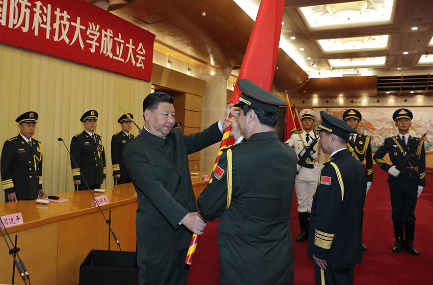 7月19日，新調(diào)整組建的軍事科學(xué)院、國防大學(xué)、國防科技大學(xué)成立大會暨軍隊院校、科研機(jī)構(gòu)、訓(xùn)練機(jī)構(gòu)主要領(lǐng)導(dǎo)座談會在北京八一大樓舉行。中共中央總書記、國家主席、中央軍委主席習(xí)近平向軍事科學(xué)院、國防大學(xué)、國防科技大學(xué)授軍旗、致訓(xùn)詞，出席座談會並發(fā)表重要講話。這是習(xí)近平將軍旗鄭重授予軍事科學(xué)院院長楊學(xué)軍、政治委員方向。新華社記者 李剛 攝