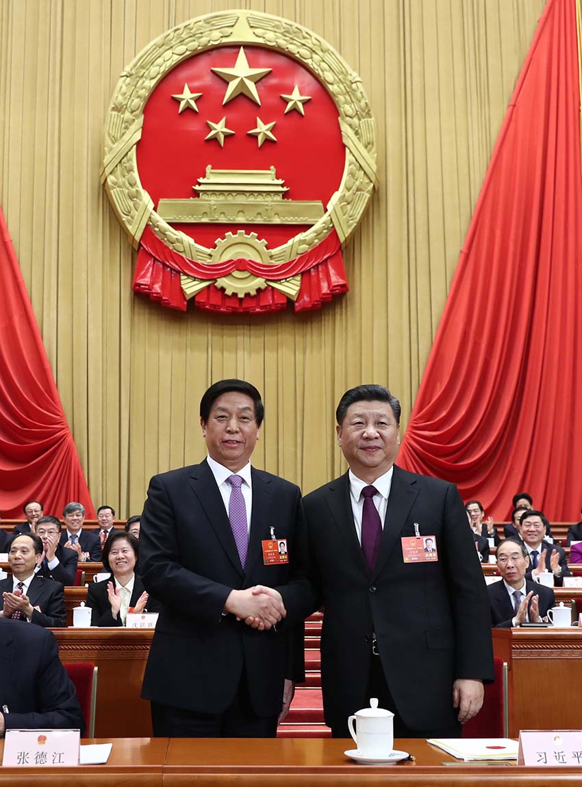 3月17日，十三屆全國人大一次會(huì)議在北京人民大會(huì)堂舉行第五次全體會(huì)議。習(xí)近平當(dāng)選中華人民共和國主席、中華人民共和國中央軍事委員會(huì)主席。這是習(xí)近平在主席臺(tái)上同新當(dāng)選的全國人大常委會(huì)委員長栗戰(zhàn)書握手。新華社記者 鞠鵬 攝