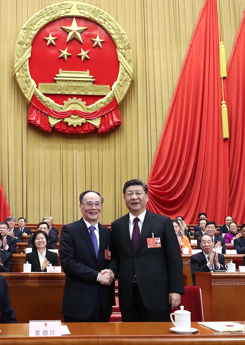 3月17日，十三屆全國人大一次會議在北京人民大會堂舉行第五次全體會議。習(xí)近平當(dāng)選中華人民共和國主席、中華人民共和國中央軍事委員會主席。這是習(xí)近平在主席臺上同新當(dāng)選的國家副主席王岐山握手。新華社記者 鞠鵬 攝