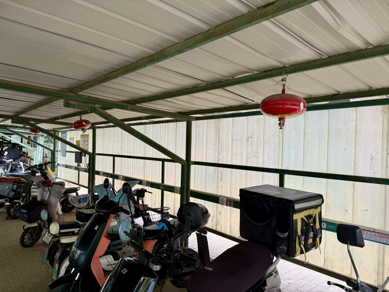 青和居小區(qū)電動車棚配備了懸掛式溫感滅火器。人民網(wǎng)記者 周恬攝